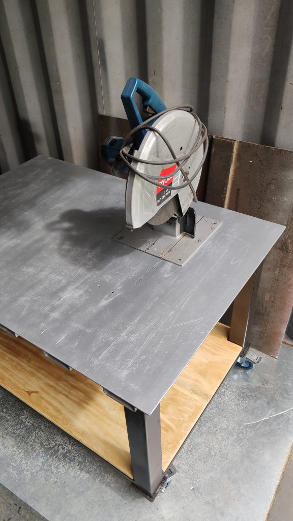 Steel workbench with removable cut-off saw.